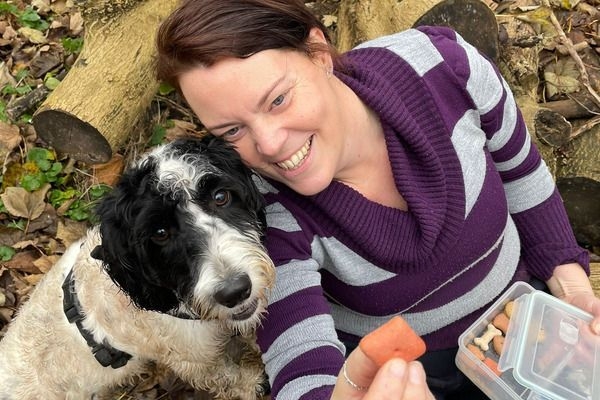 Claire with her borrowed pooch taking a break on their walkies with a doggy biscuit!