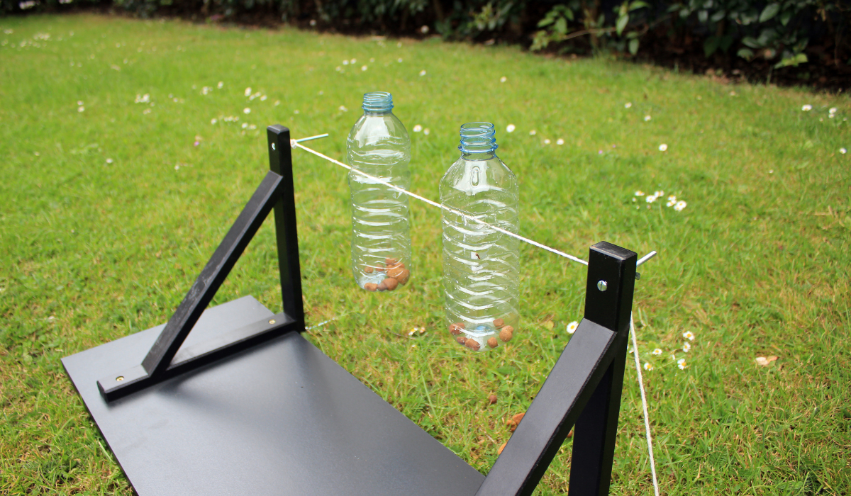 A DIY easy spin bottle filled with treats in the garden, ready for the pooch to enjoy.