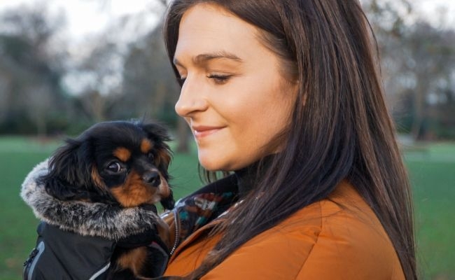 Doggy member Chilli, the Cavalier King Charles Spaniel cuddling their owner on a walk