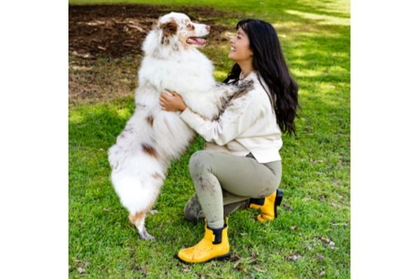 An Australian Shepherd cuddling its owner as she wears her Merry People Bobbi Boots proudly