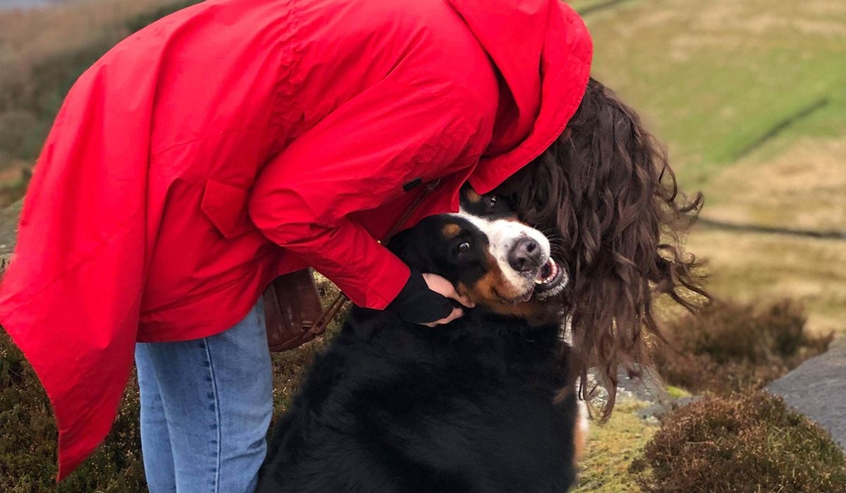 Monica leans down to hug Sophie on a country walk